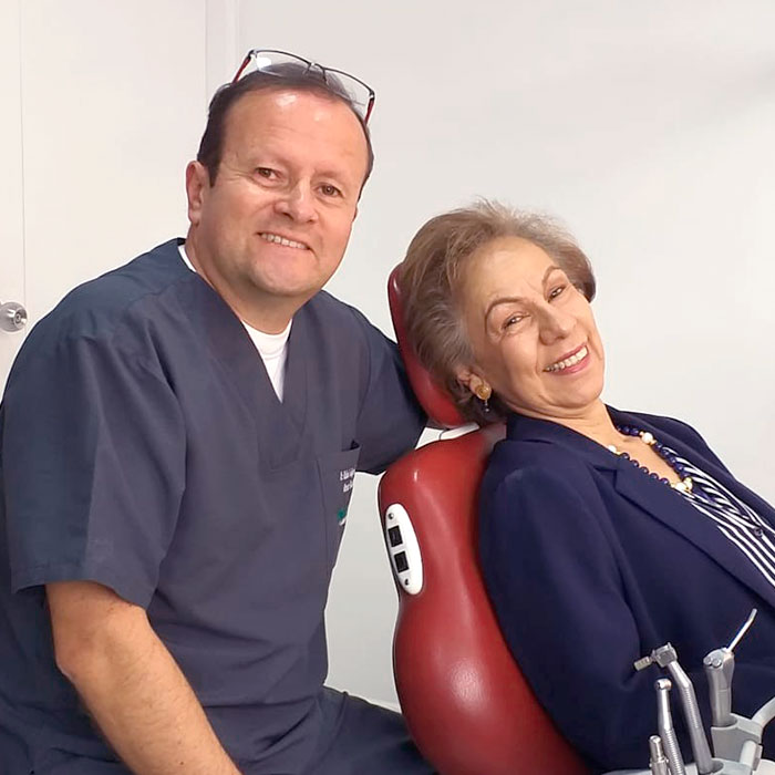 Dr Rafael Enrique Obando junto a paciente feliz de odontología en Dientes & Sonrisa