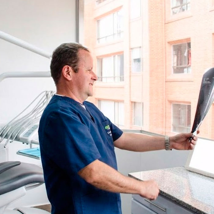 Dr rafael Obando Paez odontólogo en Bogotá sosteniendo radigrafía de paciente