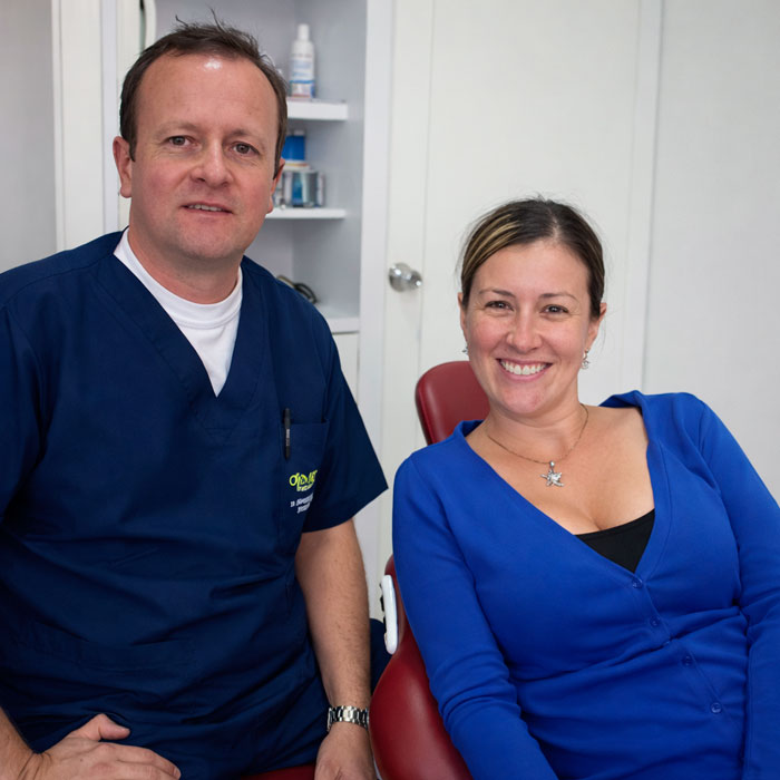 Dr Rafael Obando con paciente mujer sonriente por el resultado de su procedimiento idontológico